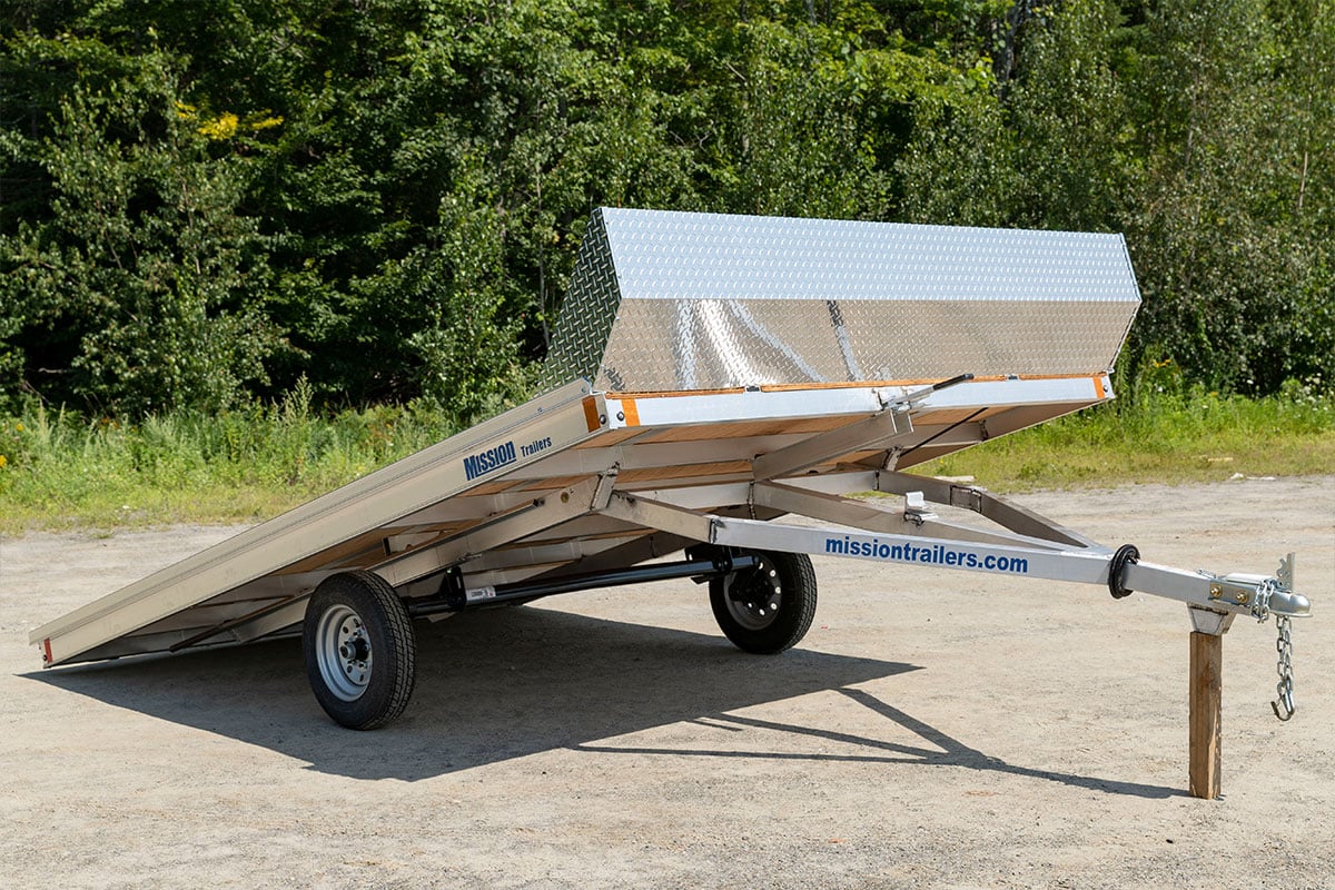 Tilting two-place open snowmobile trailer with a wood deck