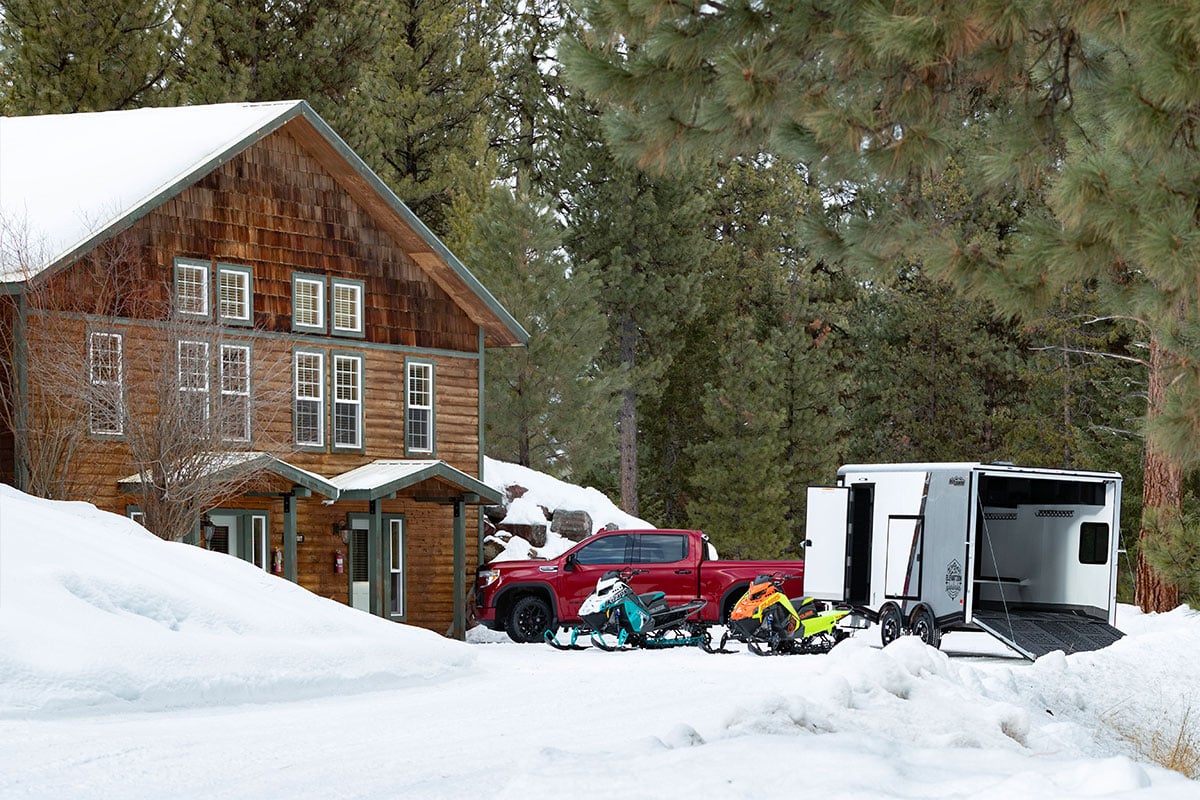 All-Sport aluminum snow trailer parked outside a log cabin