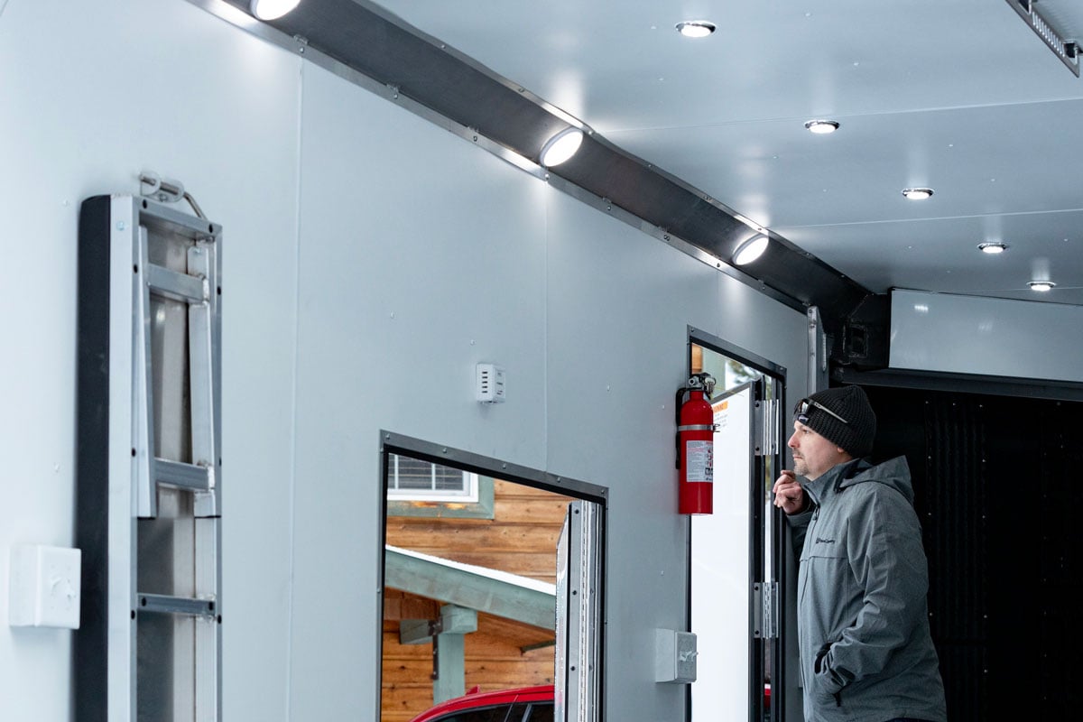Inside an Elevation Series snowmobile trailer by ALCOM featuring ceiling lights, fire extinguisher, and more accessories