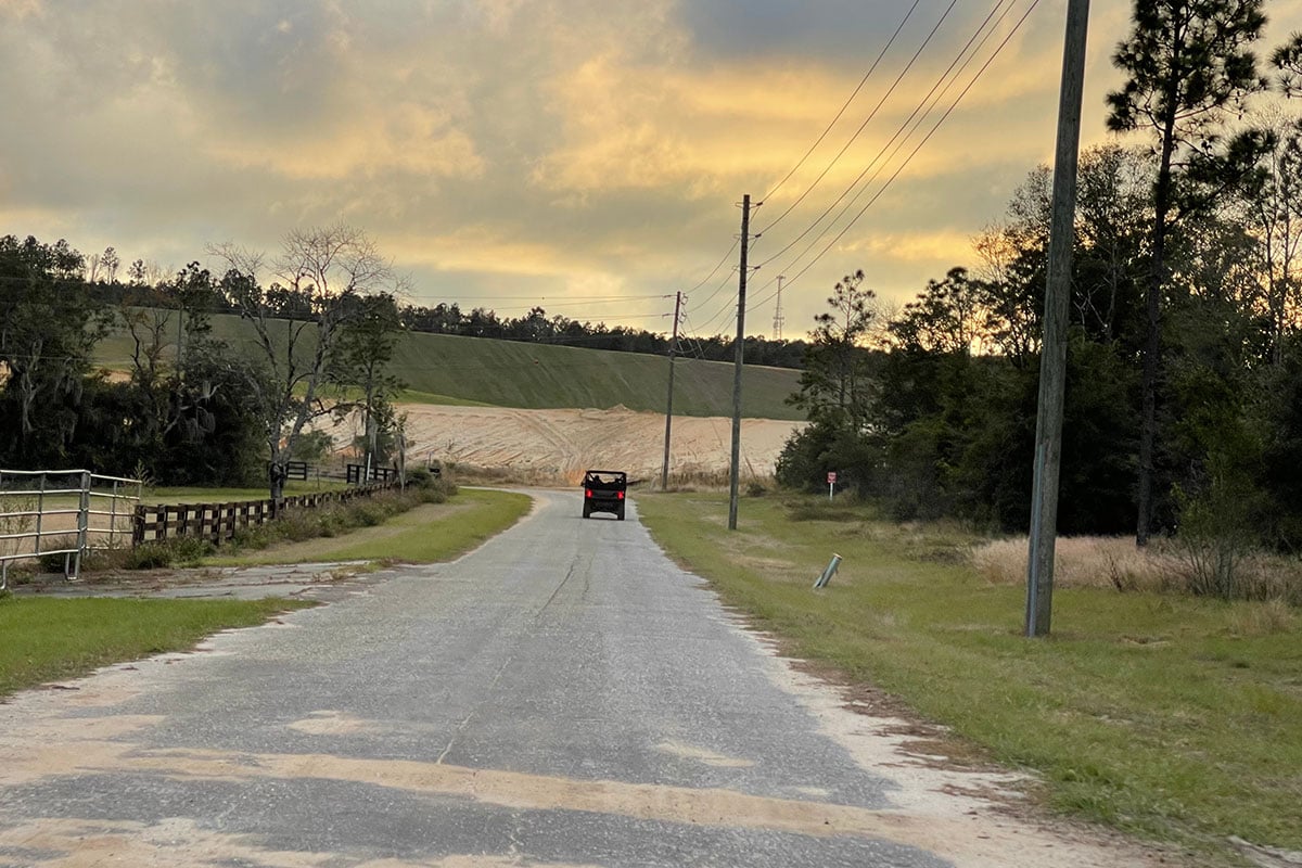 Driving a UTV along a Florida road at sunset