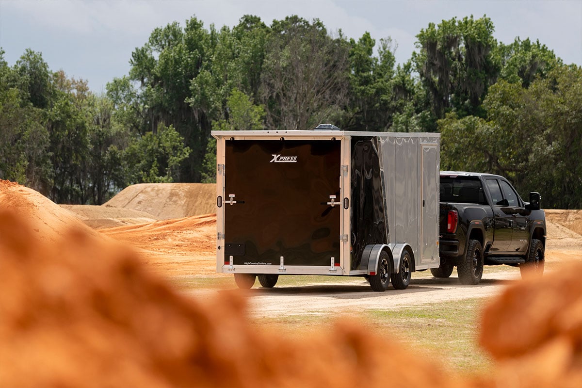 Pickup truck and enclosed motorcycle trailer driving into a Florida dirtbike track