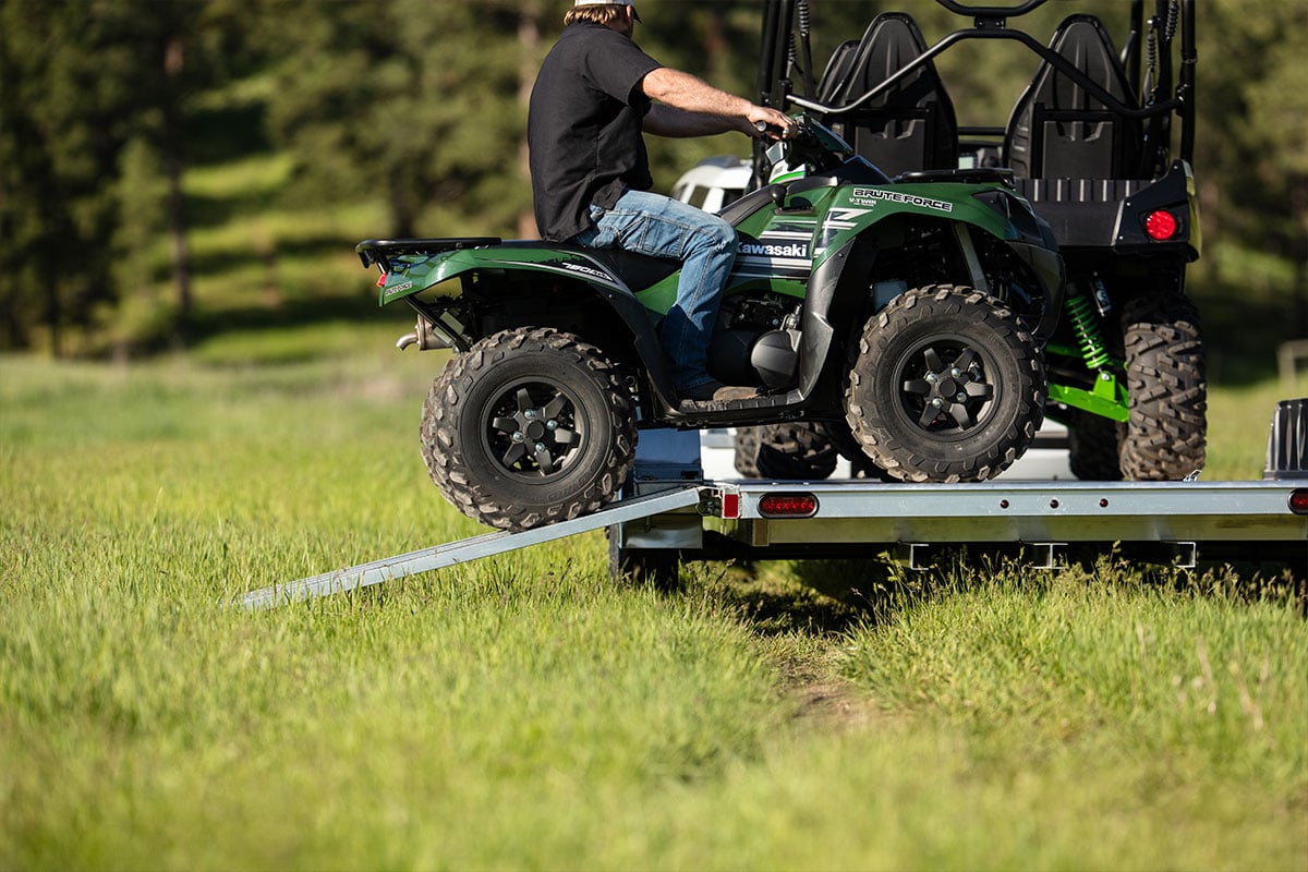 Driving an ATV onto an open aluminum ATV/UTV trailer from ALCOM
