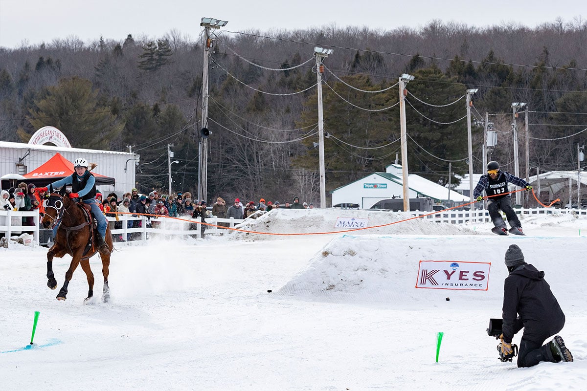 Josie rides fast while Nate flies over a jump during their Skijor race