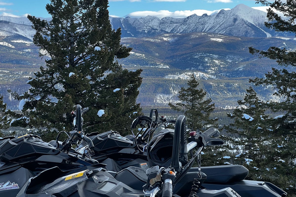 Incredible views from a scenic spot near Seeley Lake, MT, with snowmobiles parked in the foreground