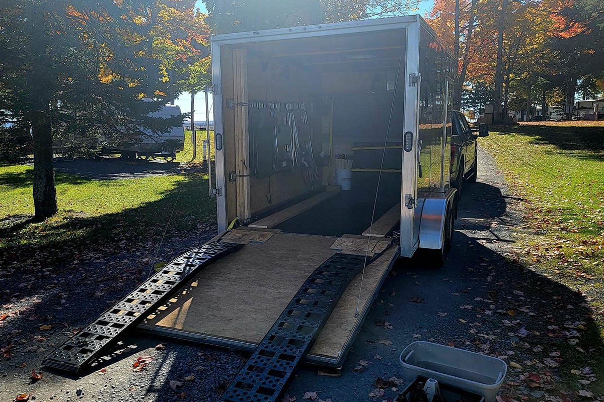 An interior view, with spring loaded rear ramp door open, of an ALCOM ATV trailer that's been custom built by a customer for adventure.