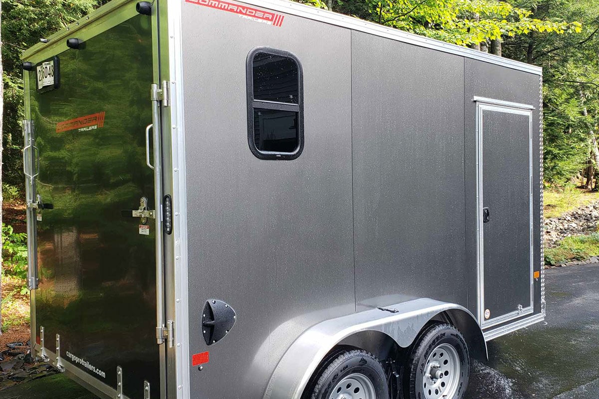Aluminum enclosed UTV / camping trailer parked with all doors, windows closed.