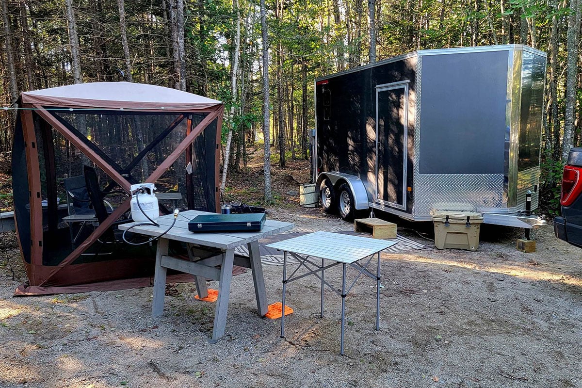 An aluminum toy hauler does double duty as a portable cabin in the Maine woods.