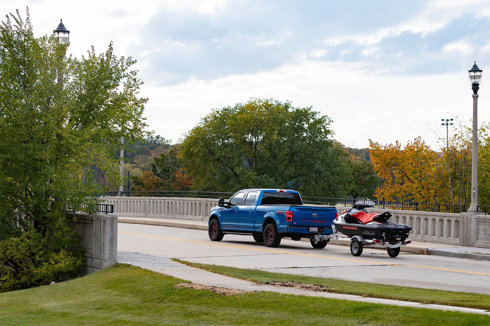 Blue pickup truck towing a Triton Wave aluminum PWC trailer