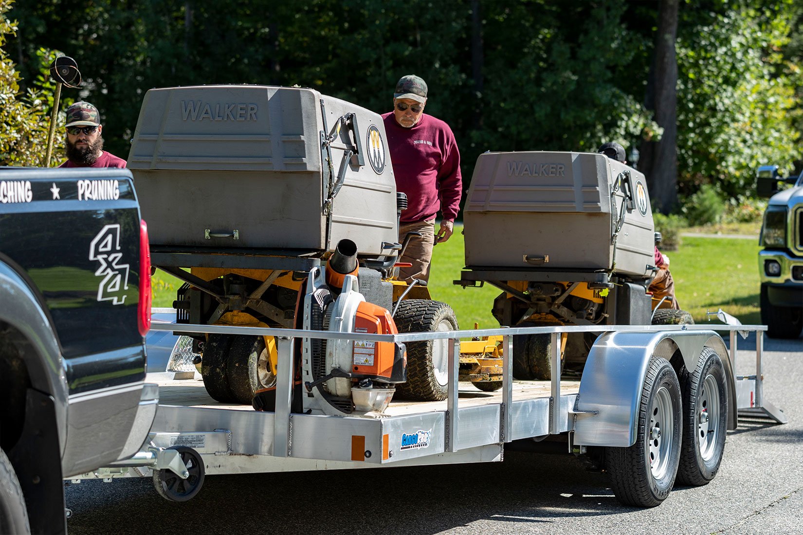 Open wood deck aluminum landscape trailer by ALCOM at a jobsite