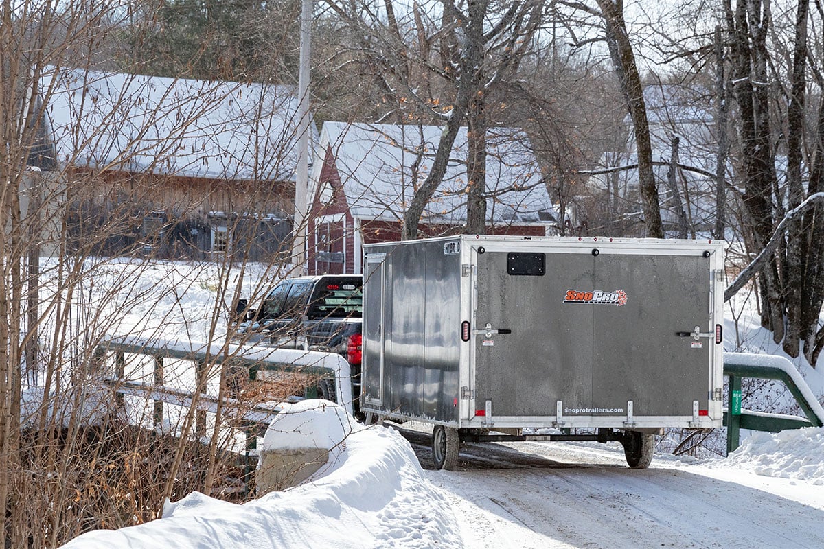 Enclosed SnoPro snow trailer on the road during winter.