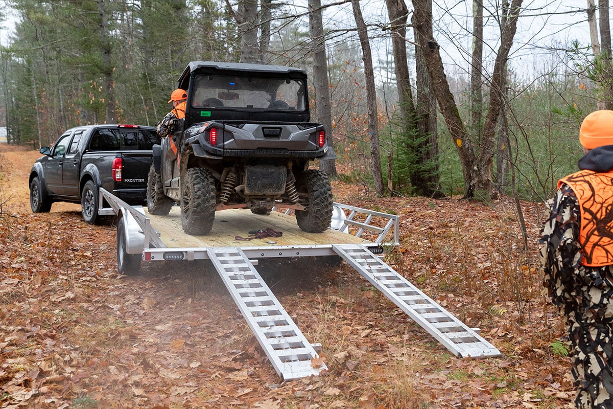 Backing an ATV off an open wood deck ALCOM trailer with rail/ramp combo ramps.