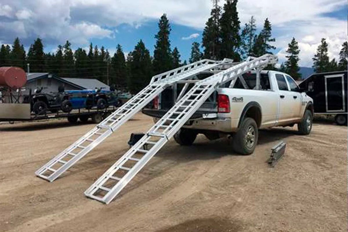 Telescoping ramp extended from ALCOM UTV rack to ground level ready to load.