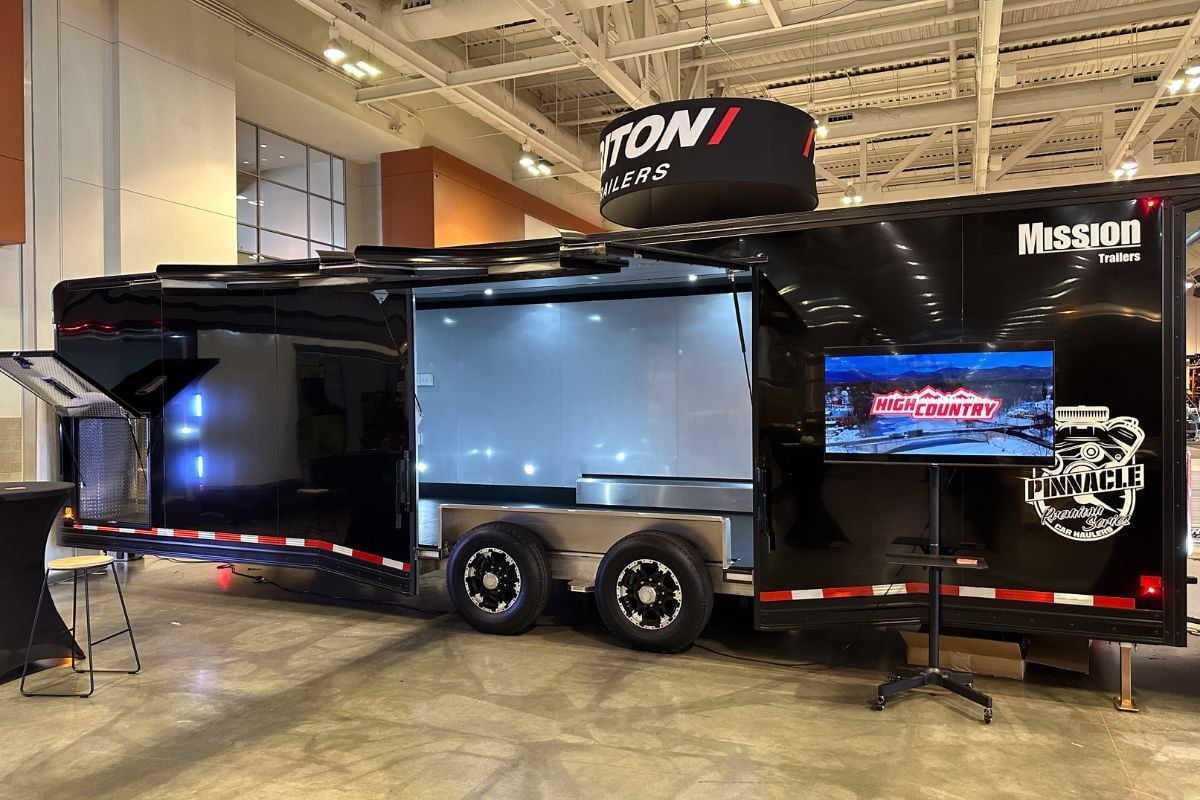 A large black enclosed aluminum trailer with escape door open at a previous NATDA Trailer Show
