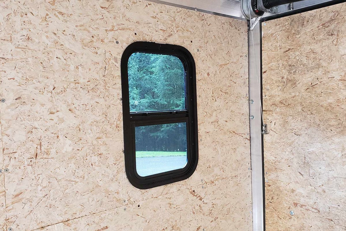 Side window installed; interior view from inside the aluminum trailer.