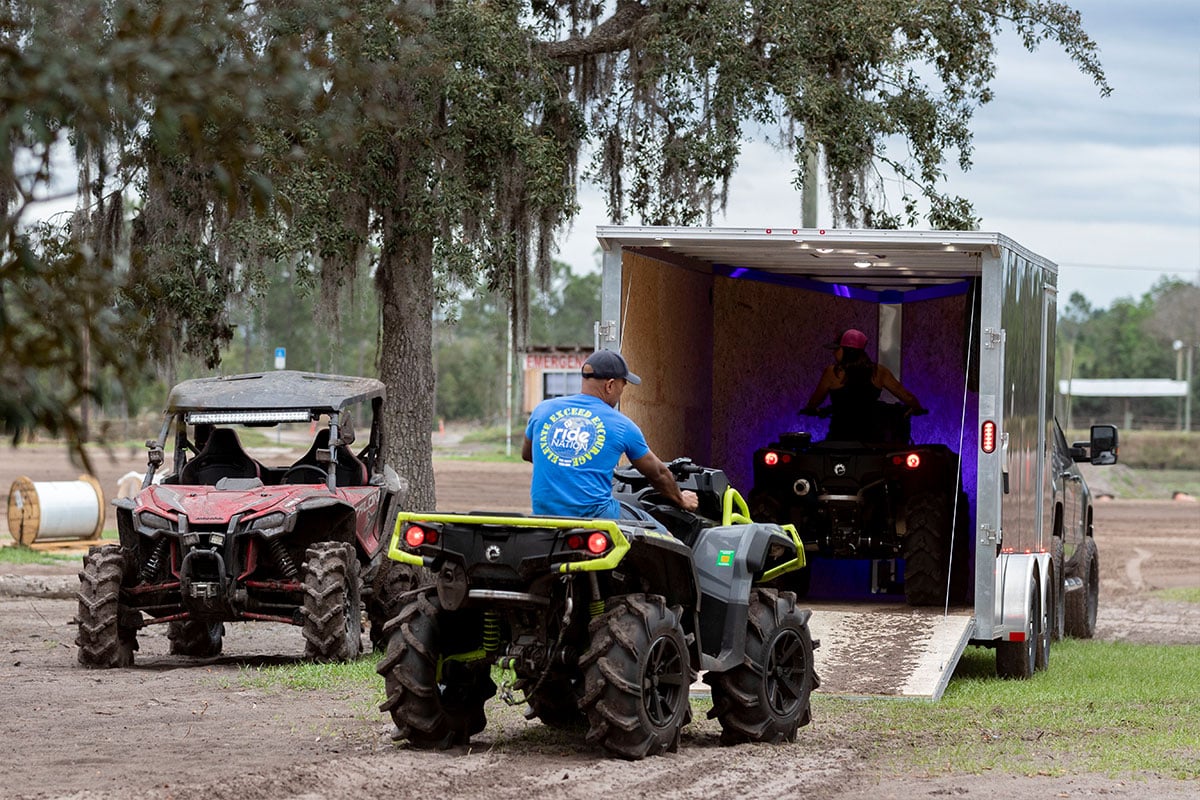 Enclosed ALCOM ATV trailer with ATVs driving in