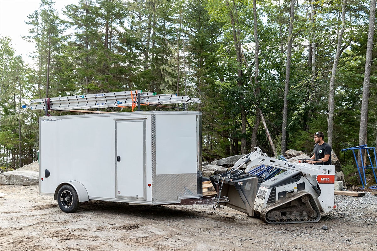 Enclosed aluminum cargo trailer with ladder racks and side door for landscaper contractor