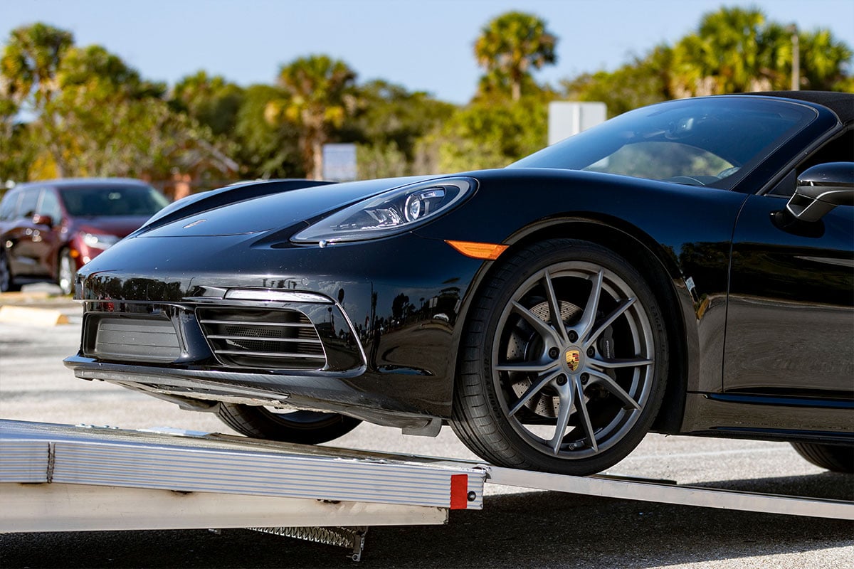 Loading a sports car onto an open aluminum car hauler by ALCOM