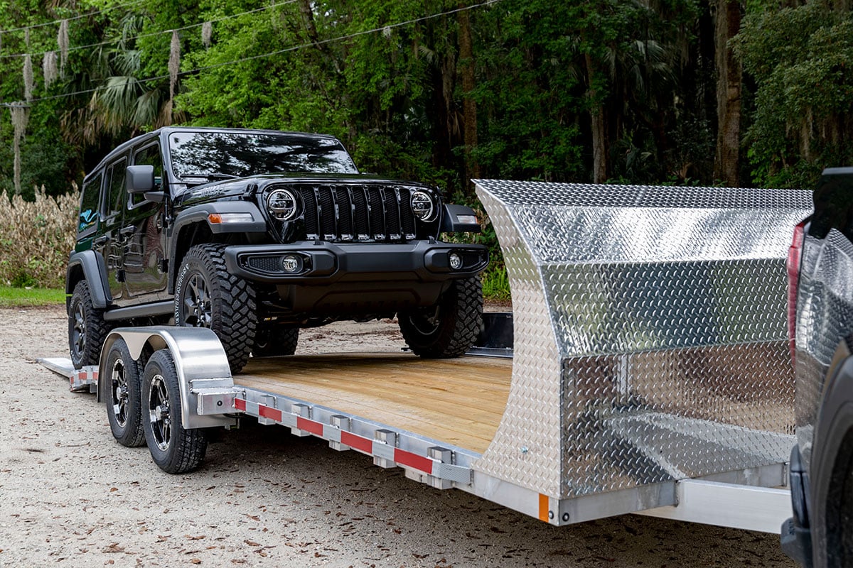 Driving a Jeep onto an open wood deck car trailer from ALCOM