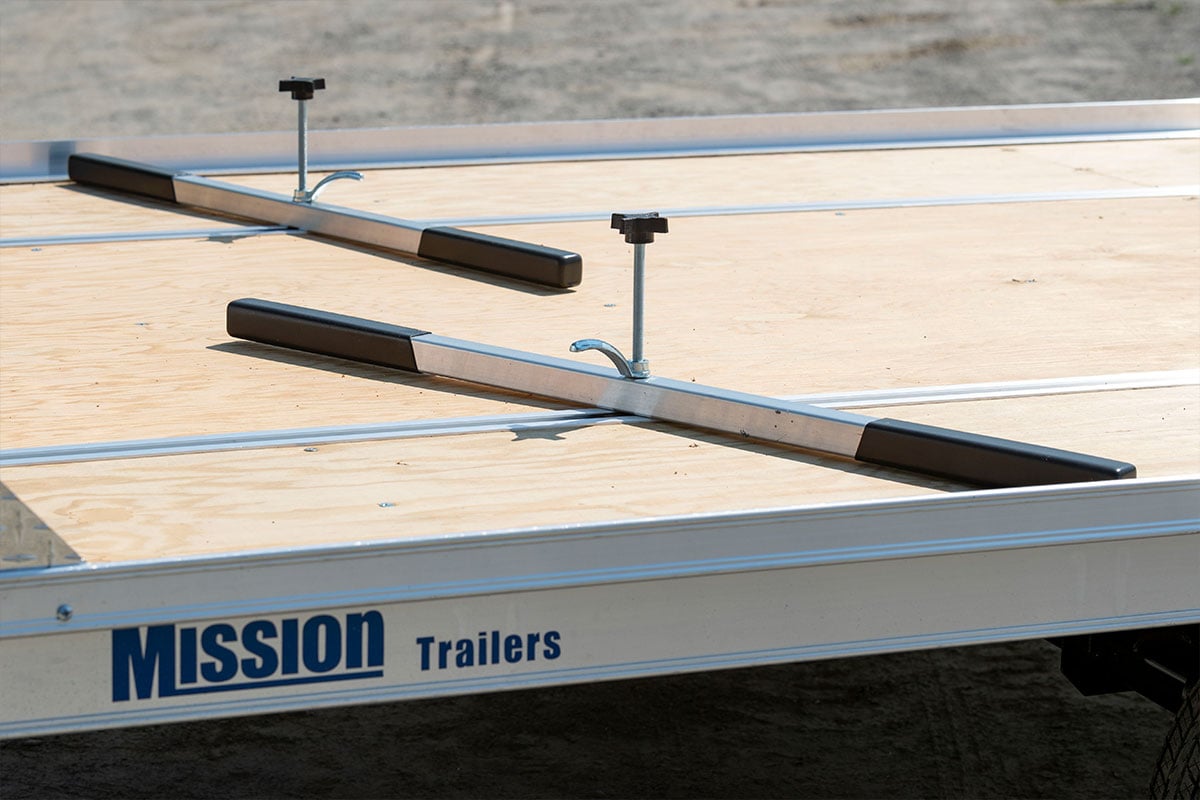 Open two-place snowmobile trailer with tie-down bars