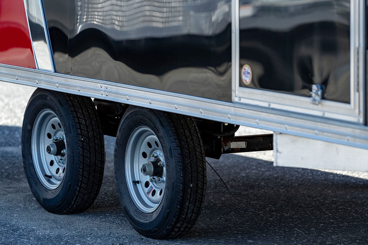 Tires, axles, siding and door of an enclosed ALCOM aluminum trailer