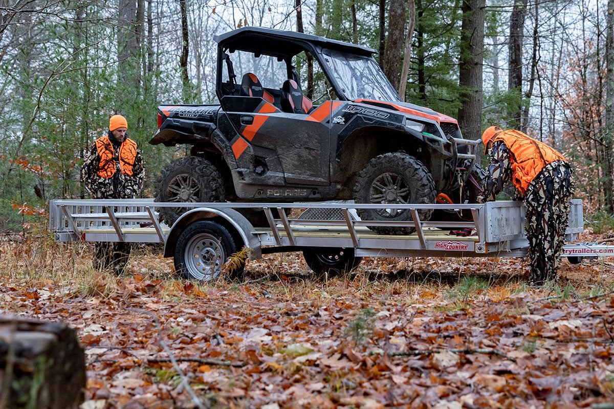 83" open ATV trailer by High Country parked in the woods, ready to unload the ATV.