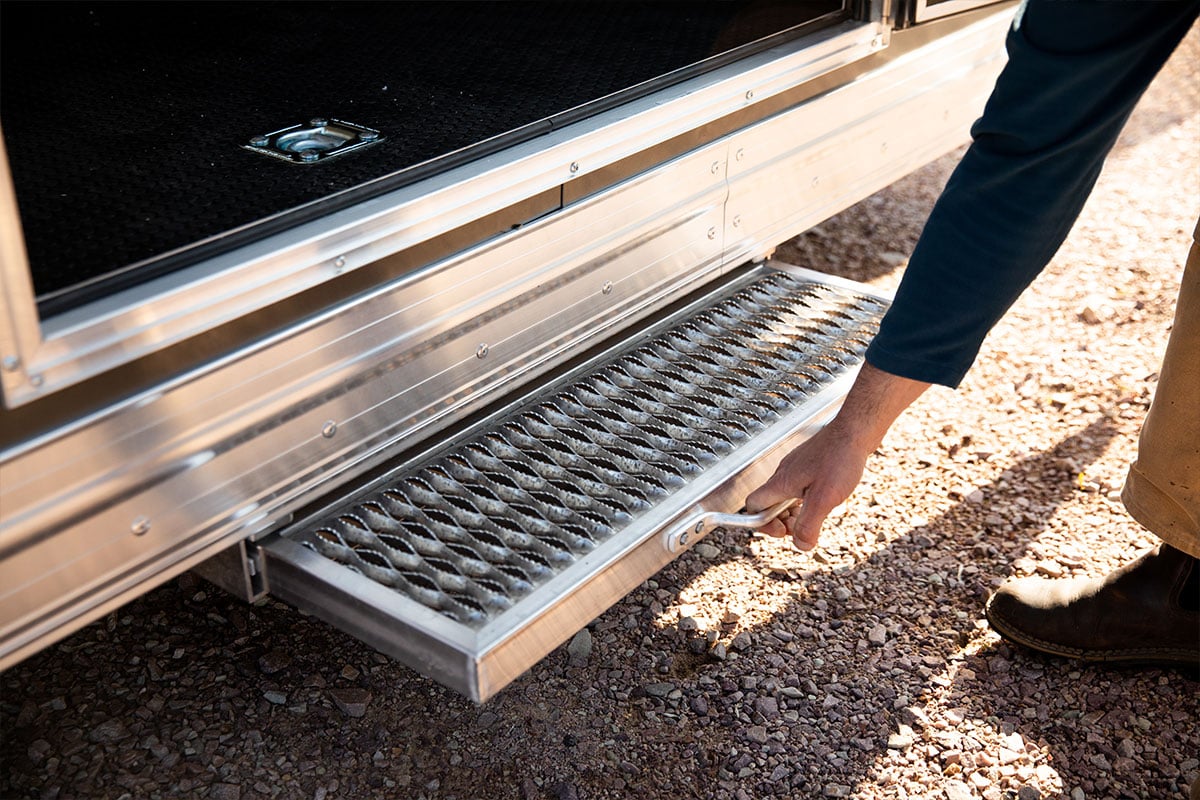 Pull-out aluminum step on an enclosed ALCOM trailer being pulled open