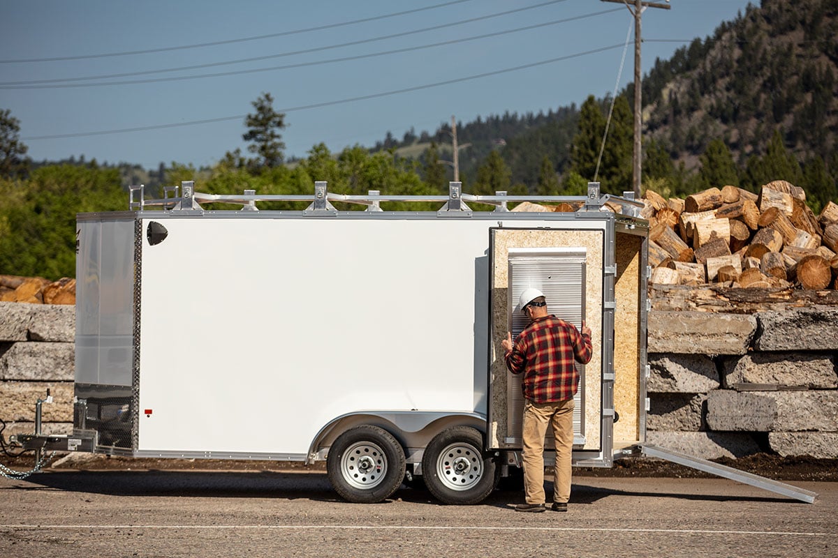 ALCOM enclosed contractor trailer with barn doors and stowaway ramps; one already placed