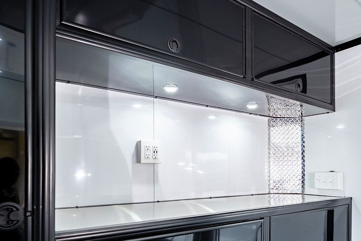 Interior lights in enclosed ALCOM trailer, mounted under cabinets, with outlets and wall switches