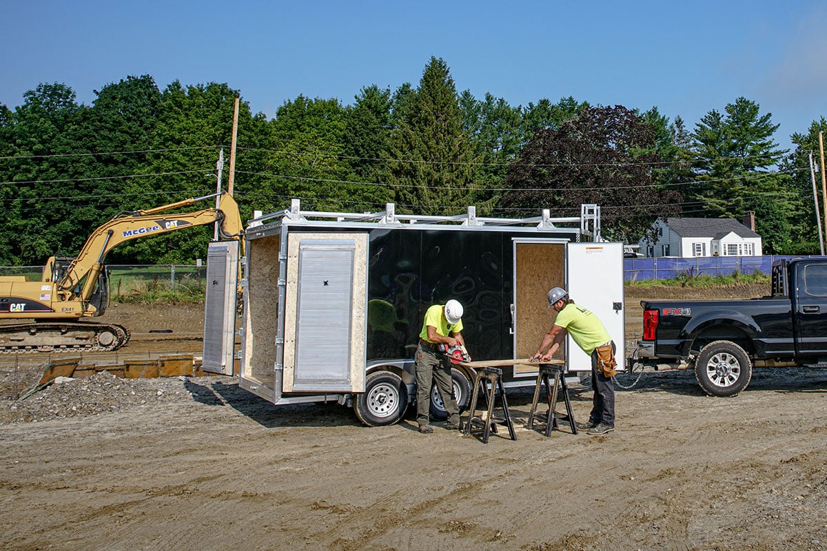 ALCOM aluminum contractor trailer with barn doors, side door, and stowable ramps