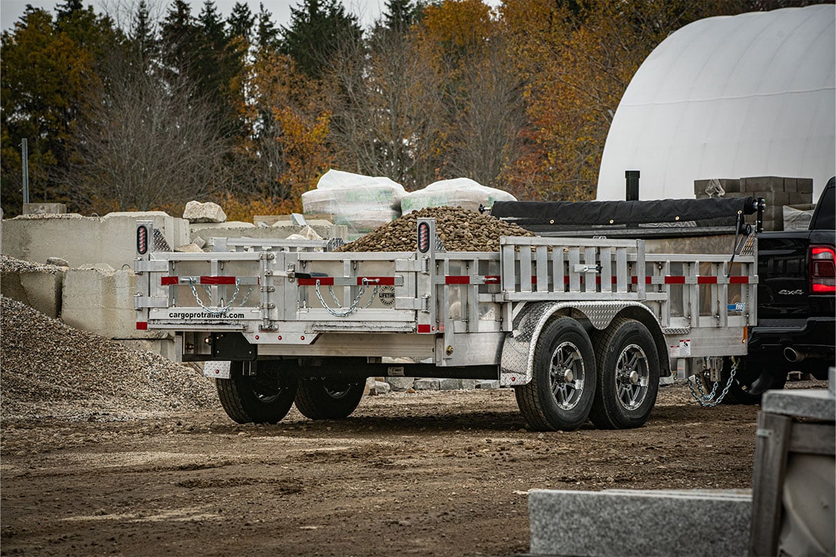 ALCOM commercial dump trailer loaded with rock at a jobsite