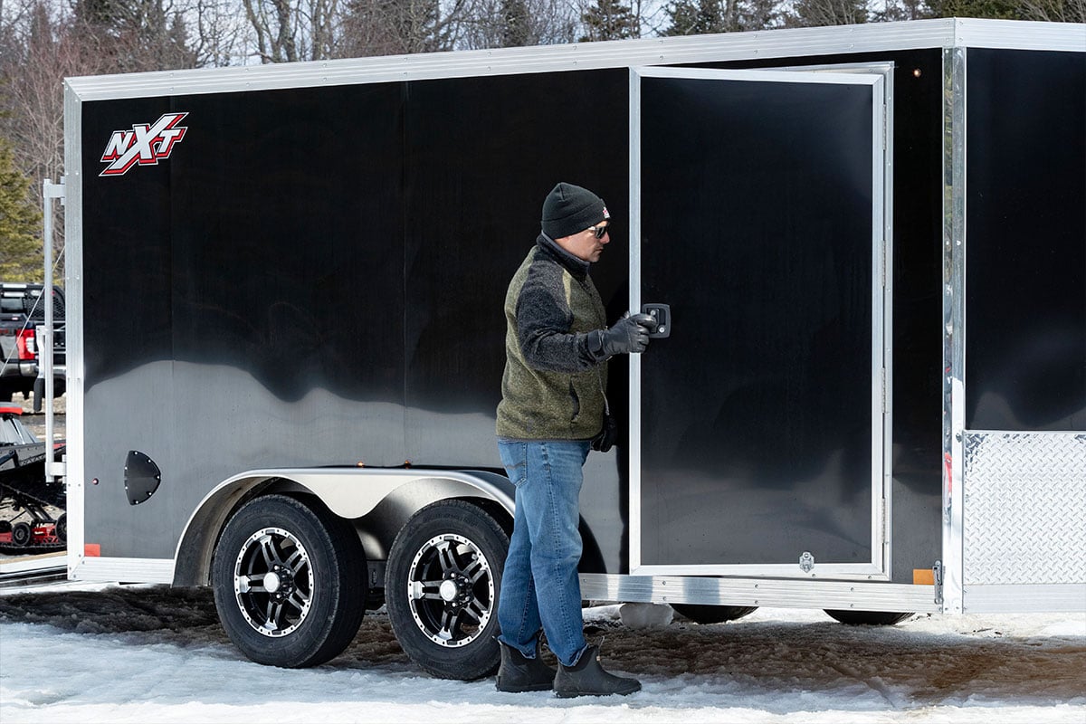 A versatile enclosed aluminum car trailer from ALCOM with a side access door