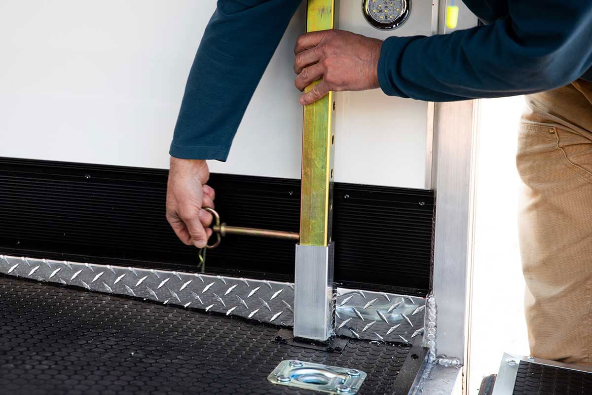 Non slip floor, recessed D-ring, and rear corner jack in ALCOM enclosed car hauler