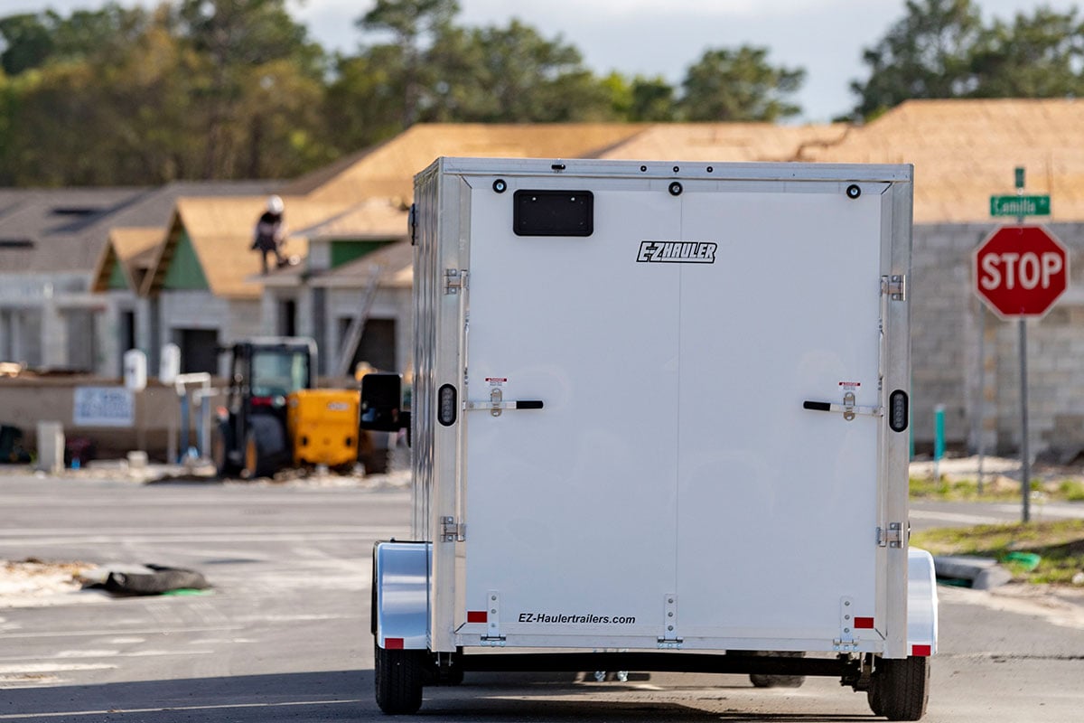 Rear view of an EZ Hauler enclosed aluminum trailer with spring assisted ramp door.