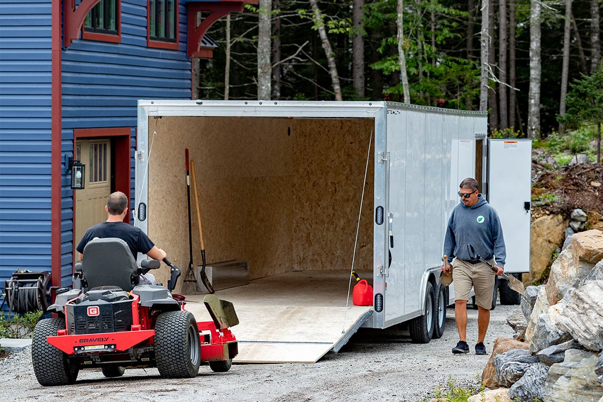 Enclosed ALCOM cargo trailer with rear ramp door and side access door open