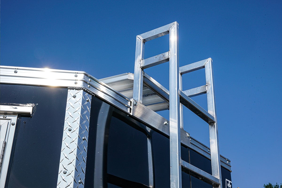 Ladder to roof catwalk and ladder rack system on an enclosed ALCOM contractor trailer.