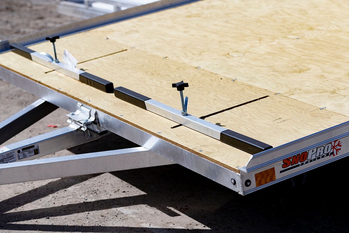 Ski tie-down bars on an open two-place snow trailer by ALCOM with marine grade deck.