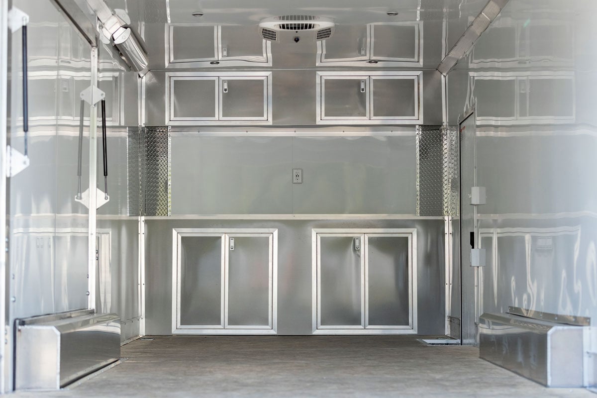 Four-door upper and base cabinets in an ALCOM flat front aluminum trailer. 