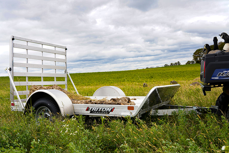 Bird hunting equipment and decoys on a Triton FIT Series aluminum trailer in a field