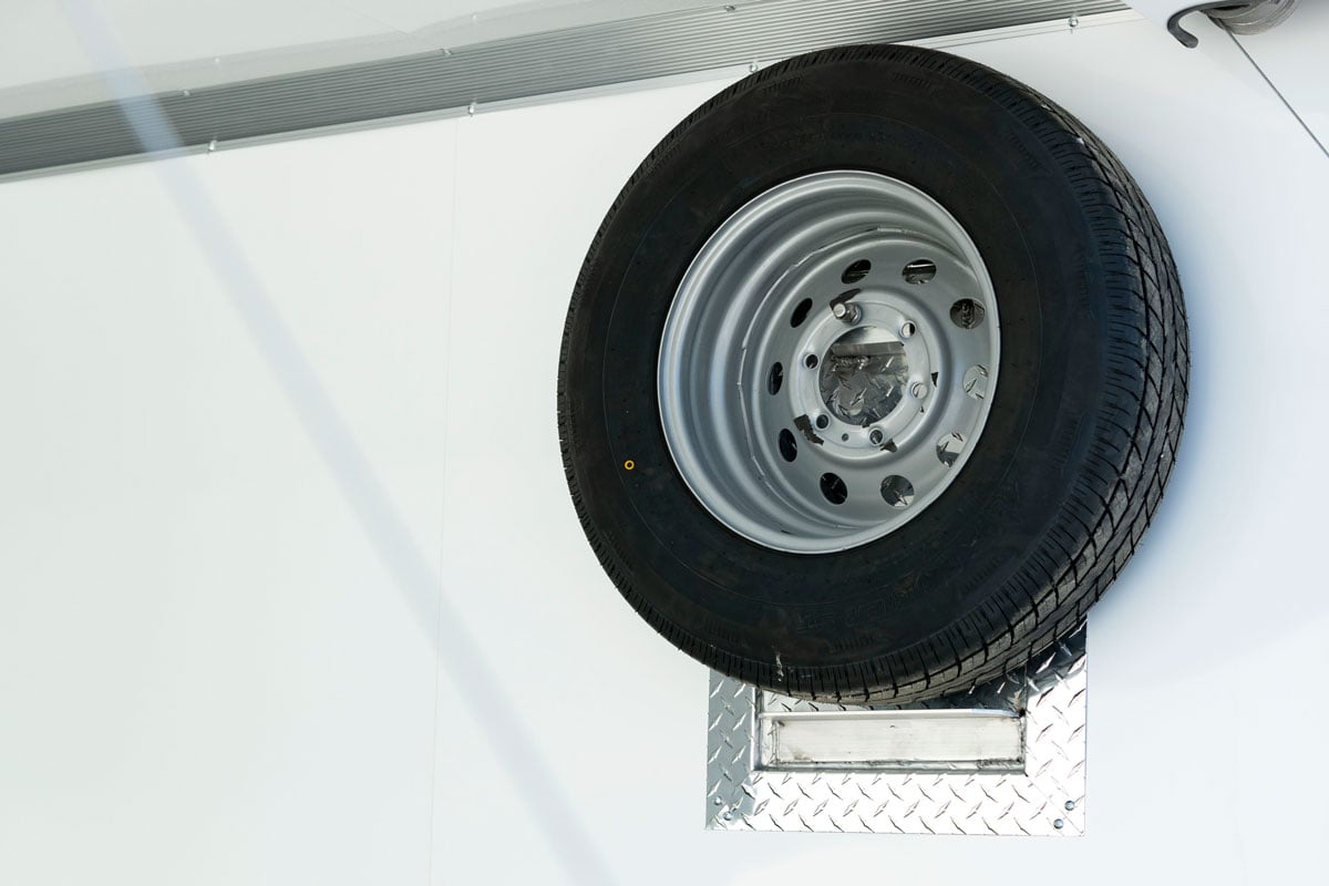 Interior elevated spare tire mount inside an ALCOM Pinnacle Series motorcycle trailer