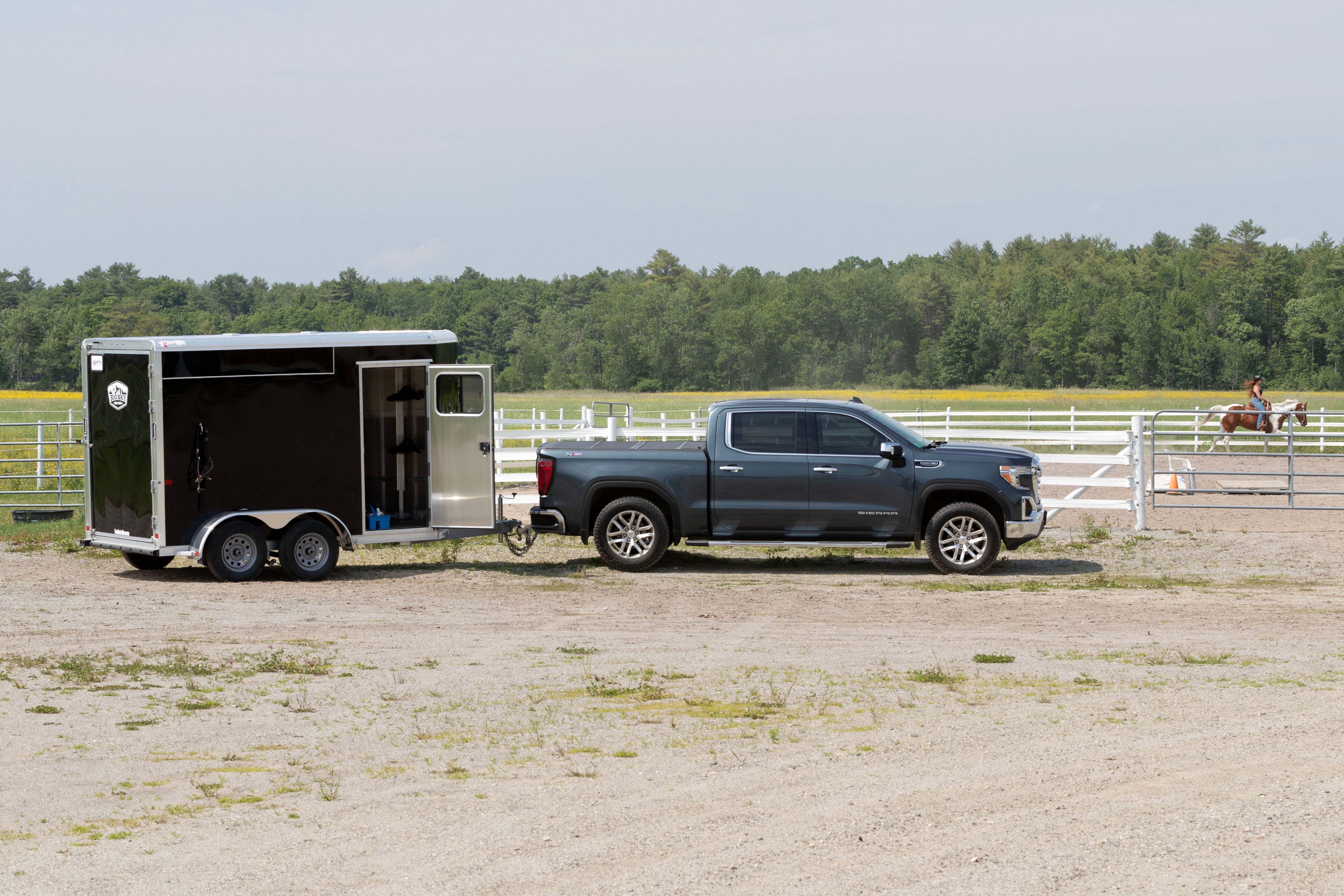 Frontier Colt Big Sky trailer parked by a riding ring hitched to a blue pickup