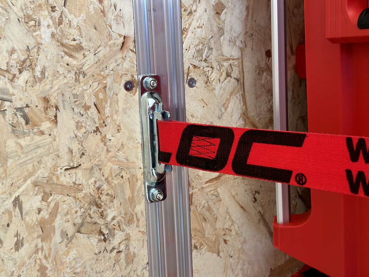 Integrated wall studs with dual rows of adjustable slide track with a cargo strap anchored in place for tool storage