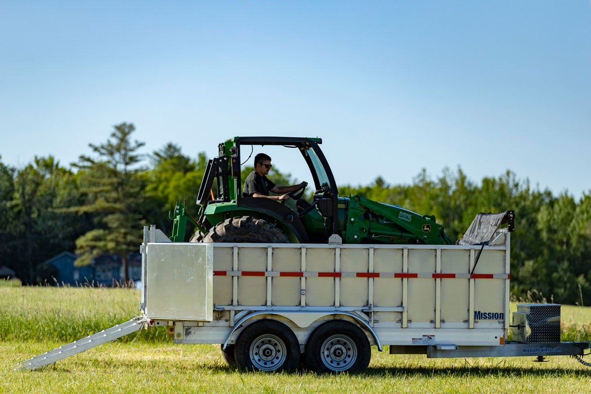 Tractor loaded into an aluminum commercial dump trailer