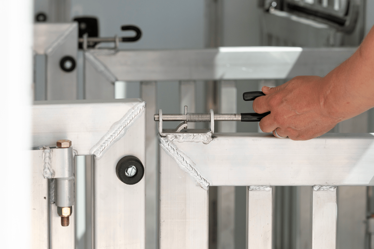 Spring latch for adjustable stalls