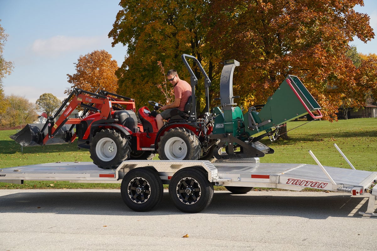 Tractor loaded onto the extruded aluminum deck of a Triton HD utility trailer