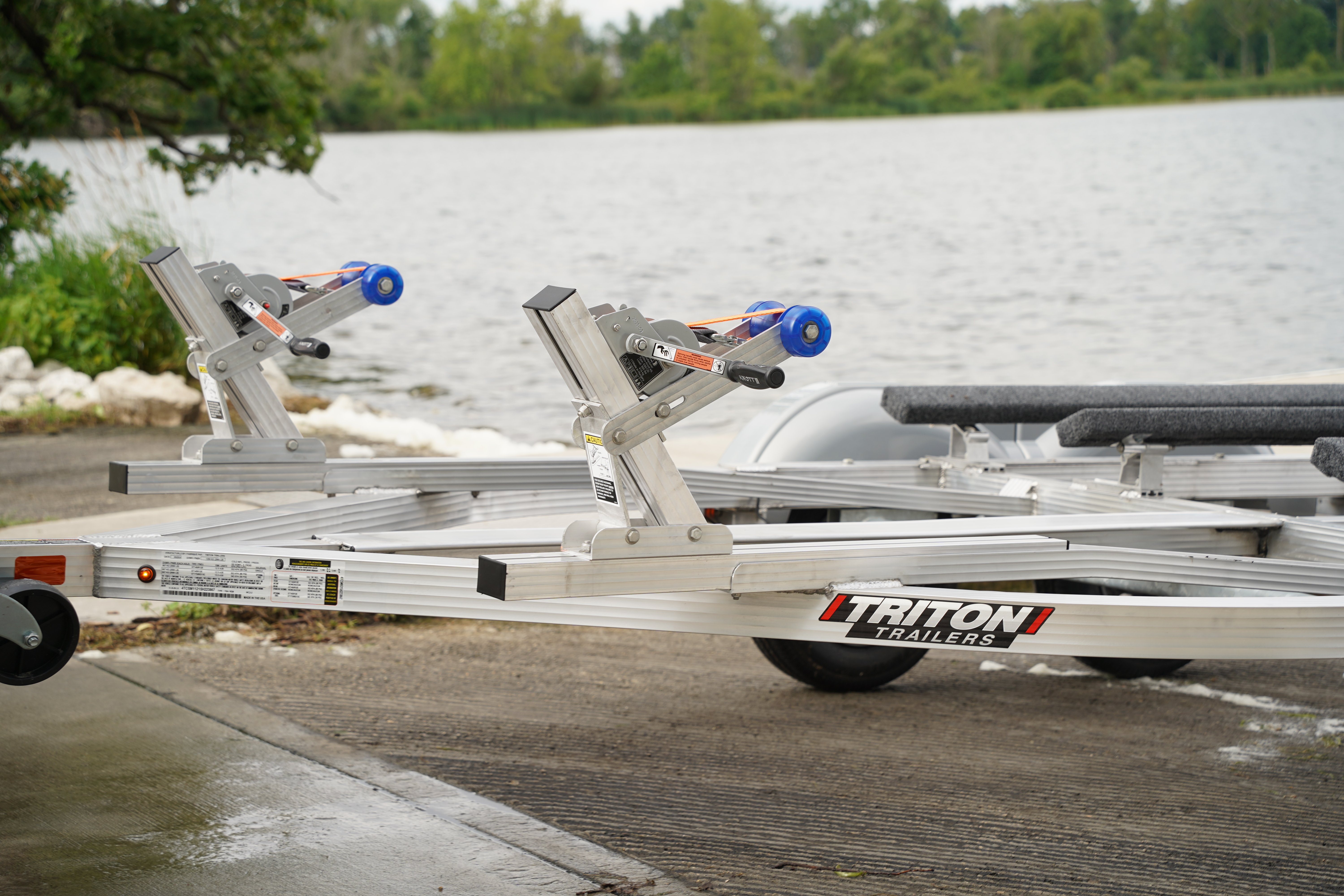 WC2-2 series aluminum PWC trailer from Triton Trailers parked on a boat ramp by a lake