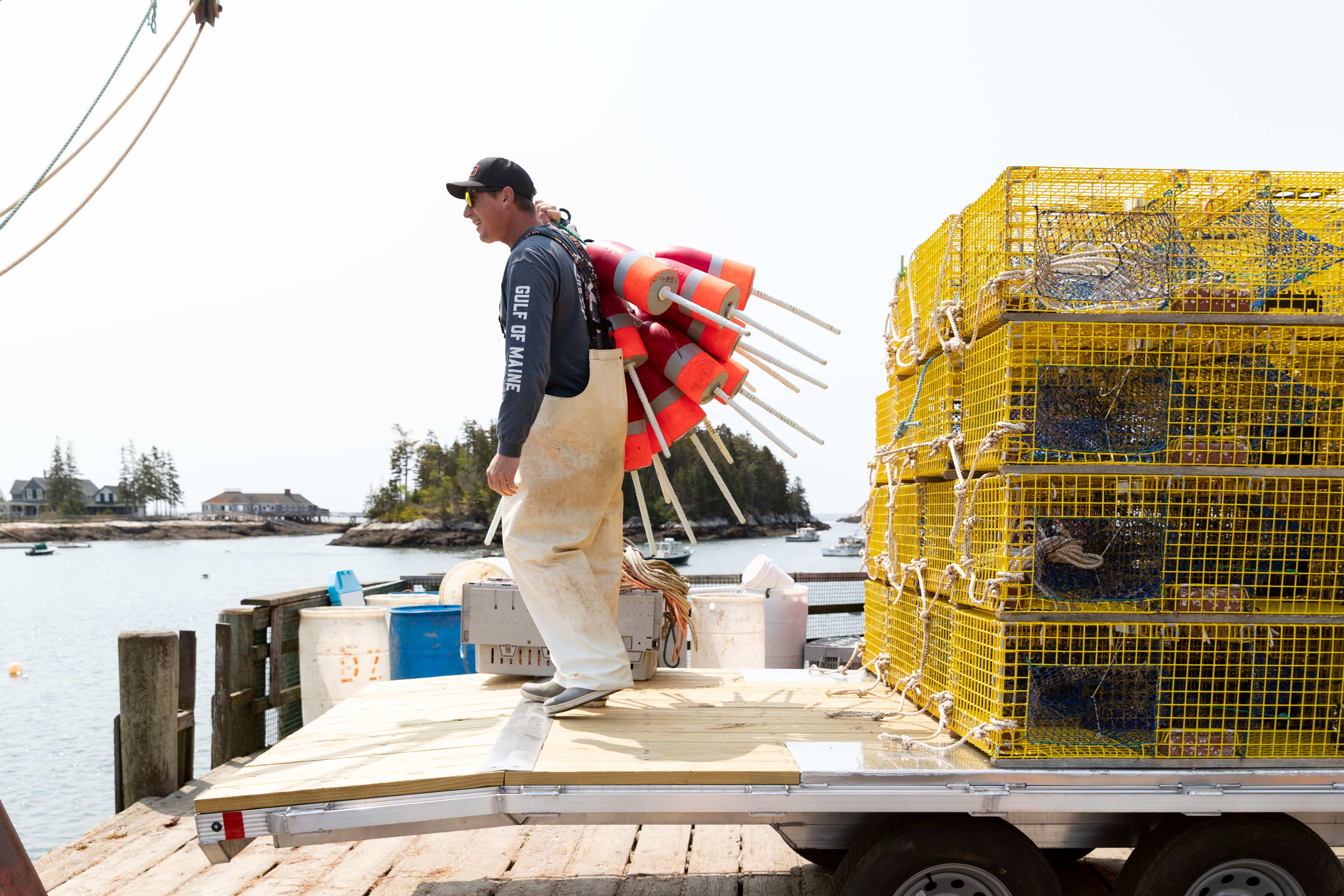 A lobsterman on the deck of an ALCOM deckover utility trailer with all welded rust resistant frame