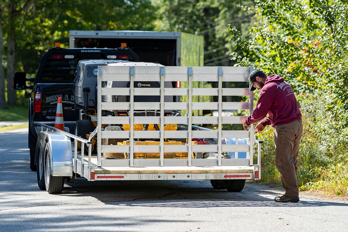 Open wood deck utility trailer at a landscaping jobsite