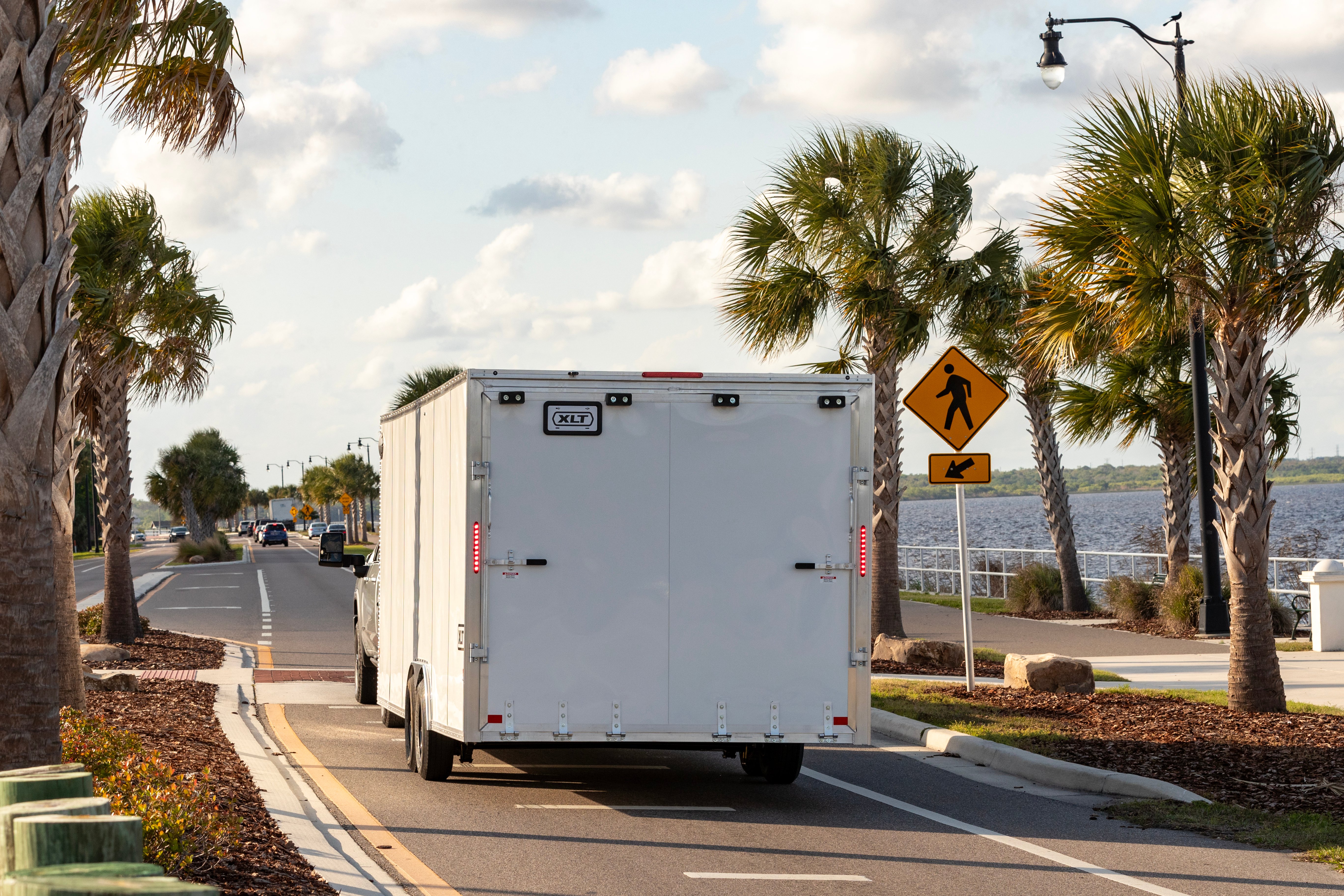 Pickup truck towing an ALCOM XLT Series car hauler in Florida near the ocean