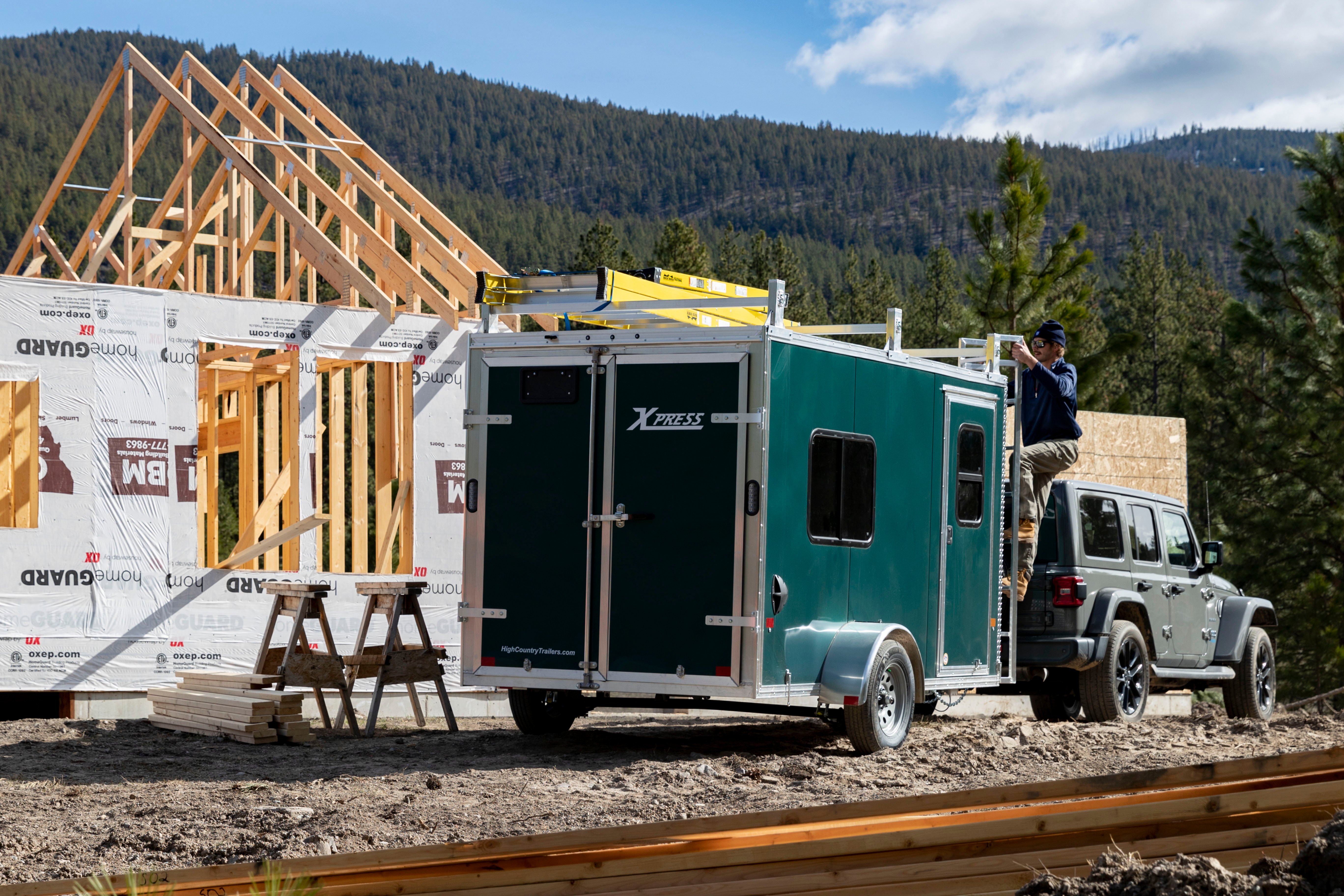 A green aluminum Ultimate Contractor Package trailer on a construction jobsite 