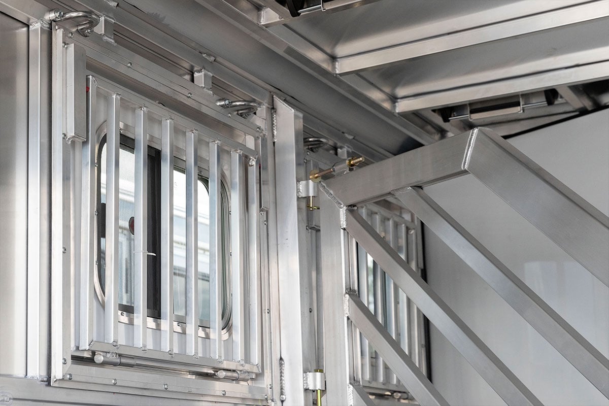 Interior view of drop-down feed windows with aluminum bars in a Frontier horse trailer